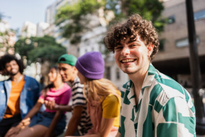 Gruppe junger Menschen lacht gemeinsam im Freien – Symbol für Freiheit und Selbstfindung im Single-Leben
