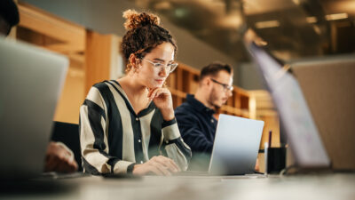 Junge Frau arbeitet fokussiert am Laptop – Sinnbild für Selbstverwirklichung und Unabhängigkeit im Single-Leben mit 20