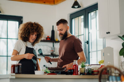 Paar kocht gemeinsam in moderner Küche – authentische Zweisamkeit statt großer Gesten