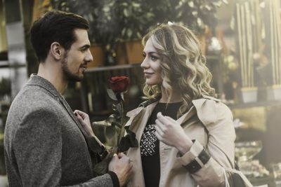 Mann überreicht Frau rote Rose – symbolisiert respektvolles Kennenlernen und Wertschätzung beim Dating
