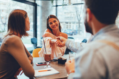 Freunde lachen und unterhalten sich in einem Café – Blindmate Dating App