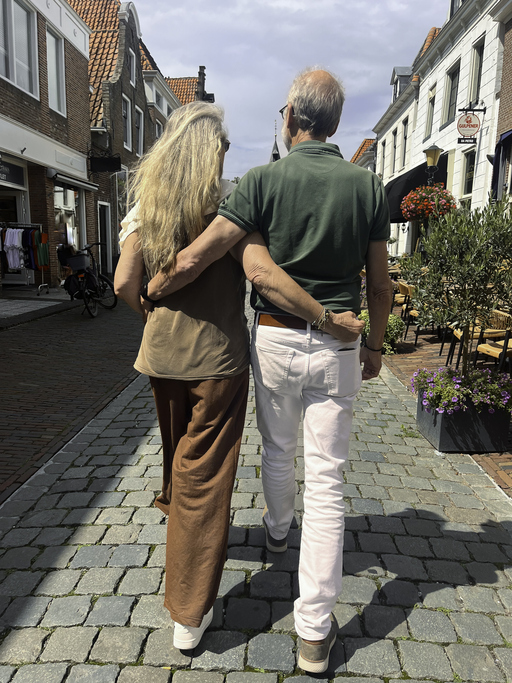 Paar geht Arm in Arm durch eine Altstadt – entspanntes erstes Date als Spaziergang, unkompliziert und ohne Kostenfalle.