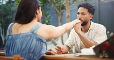 Mann küsst einer Frau bei einem Date die Hand als Symbol für Respekt, Wertschätzung und ernst gemeintes Interesse